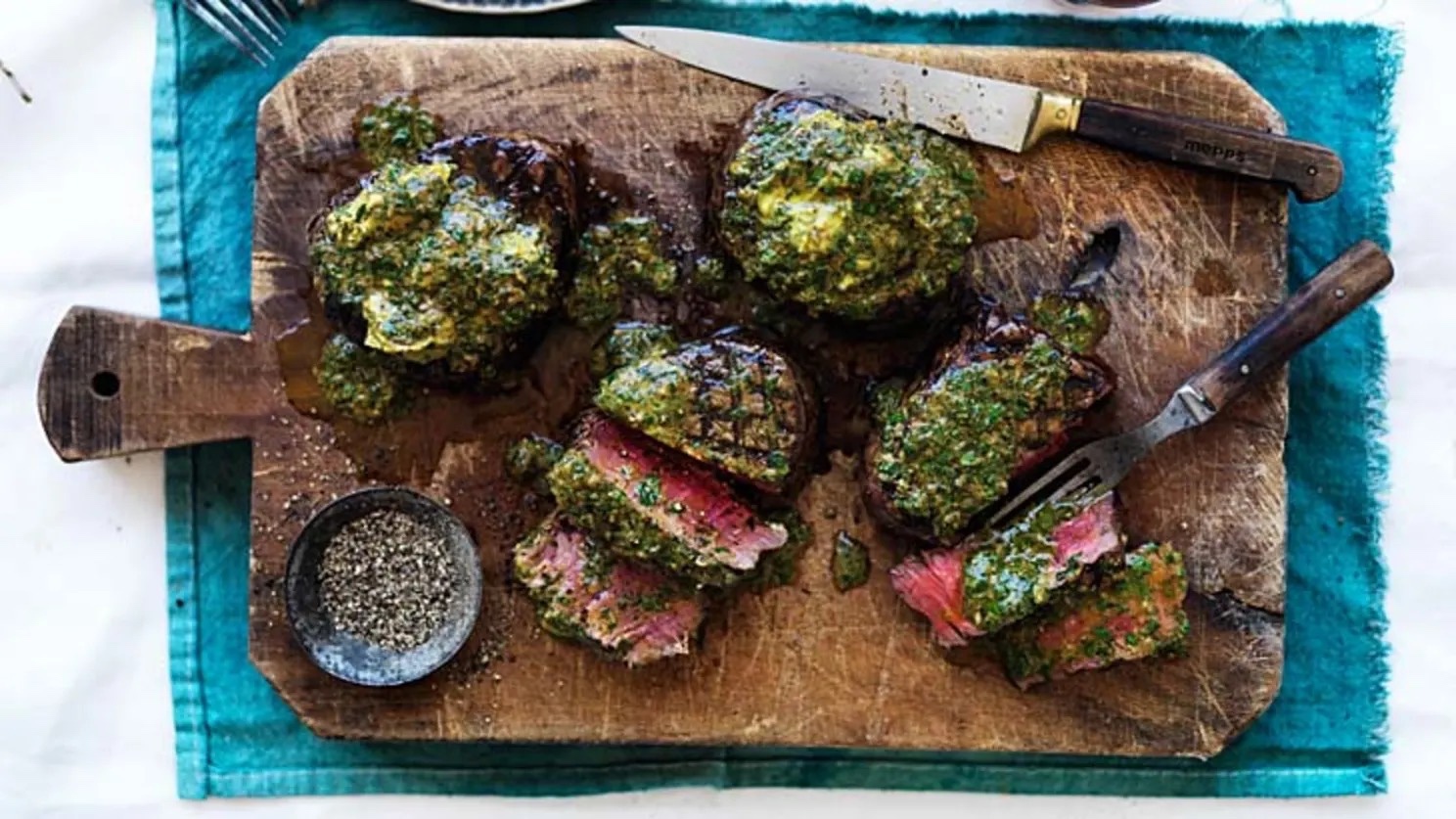 Grilled steak topped with chimichurri, sliced and ready to share