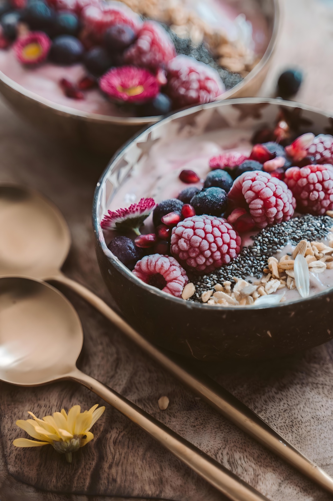 A smoothie bowl topped with mixed berries, granola and chia seeds