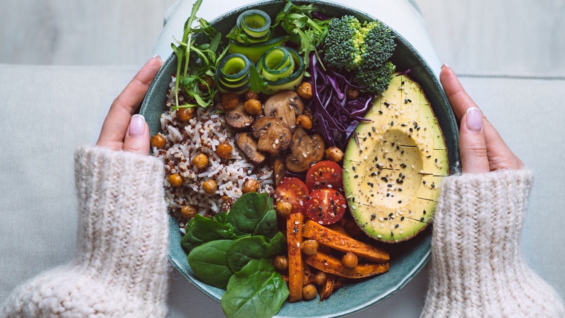 A nourish bowl with rice, quinoa, roasted chickpeas, avocado and vegetables